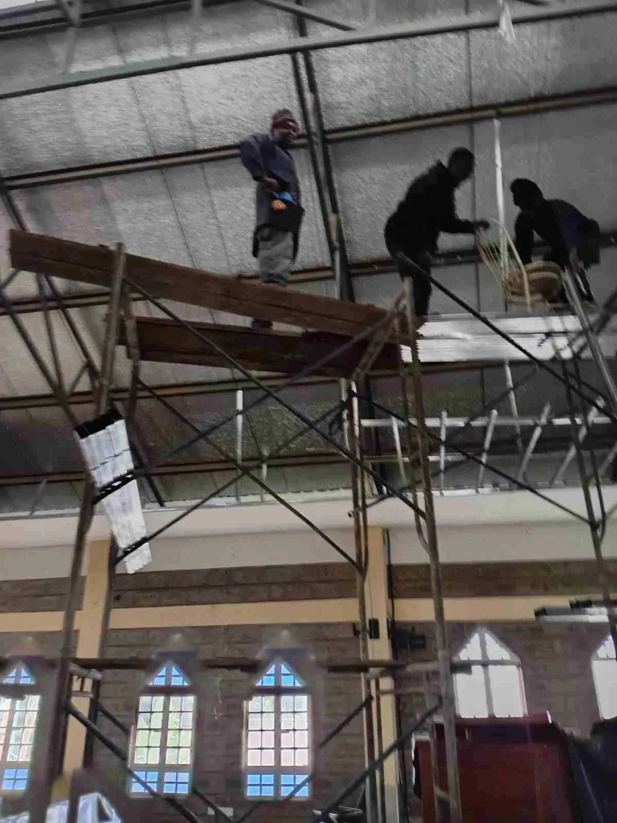 Installers on scaffolding fixing the high ceiling and roof structure