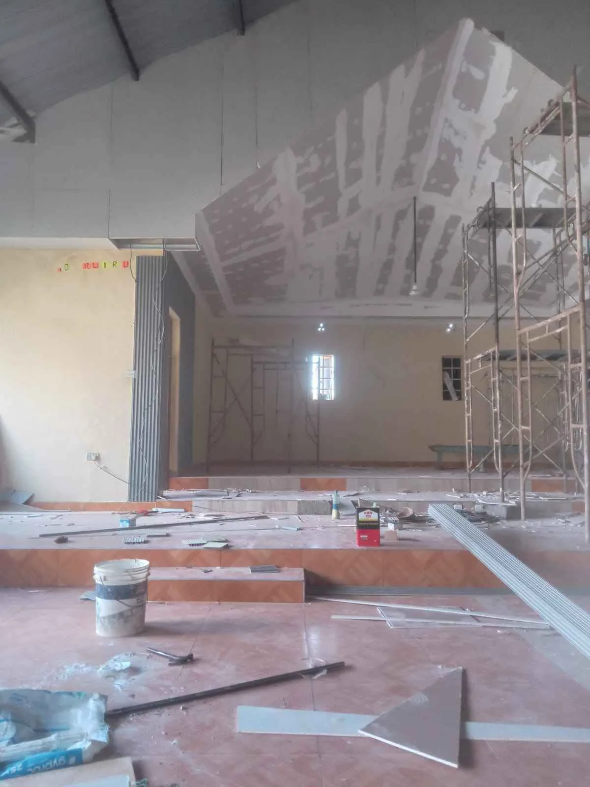 Before: church hall under construction with scaffolding and unfinished ceiling