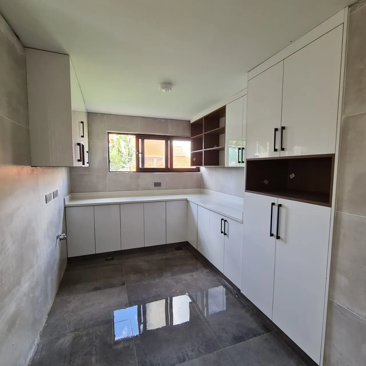 White gloss U-shaped kitchen with porcelain floor, Kilimani apartment