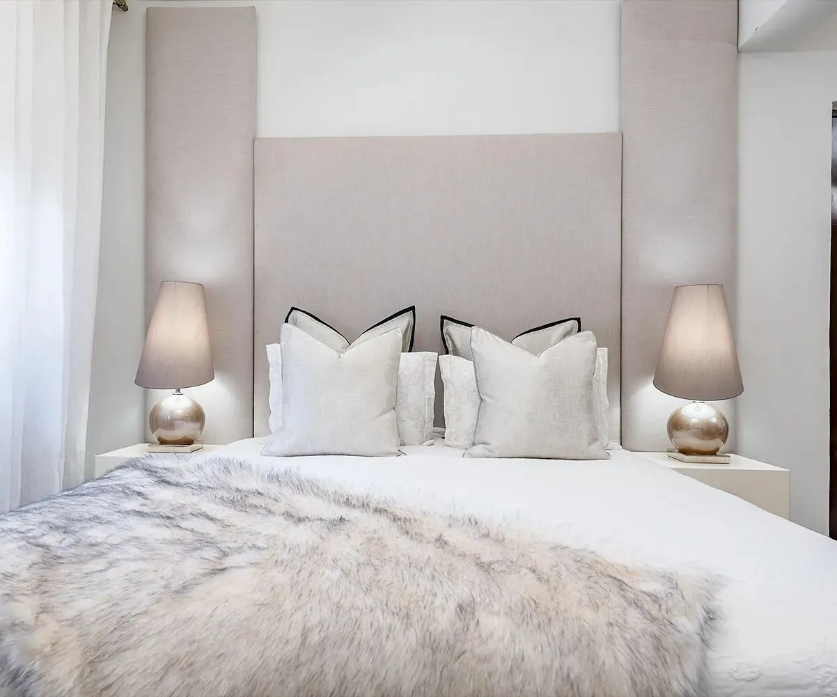 Guest bedroom with layered bedding and bedside lamps, Lavington
