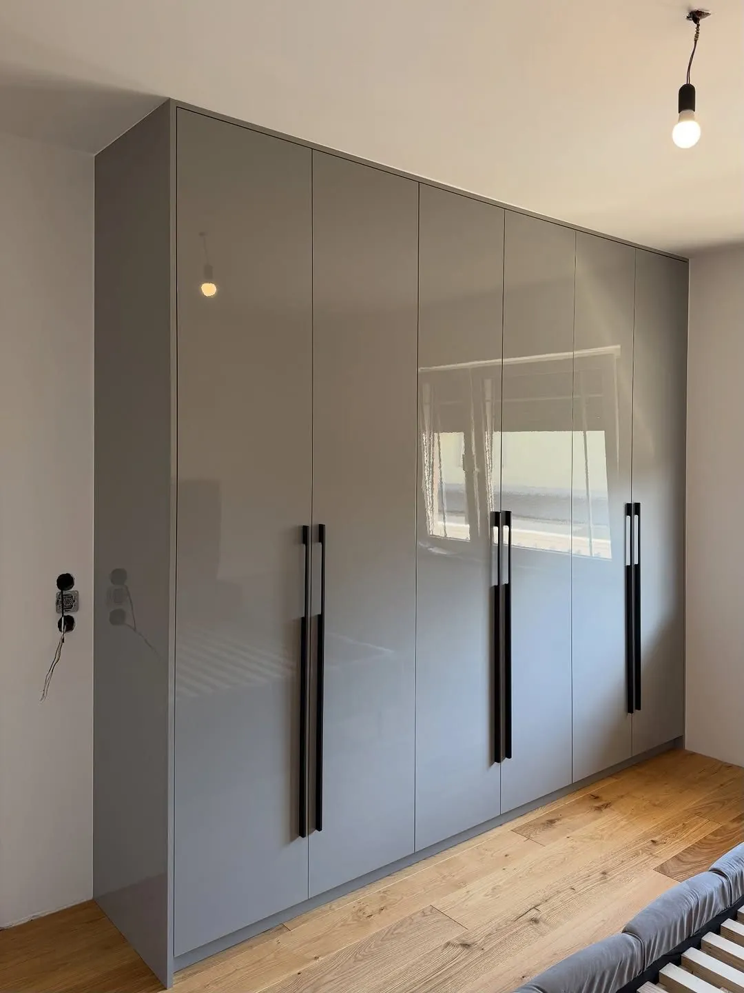 Fitted gloss wardrobe with pendant lighting in the bedroom