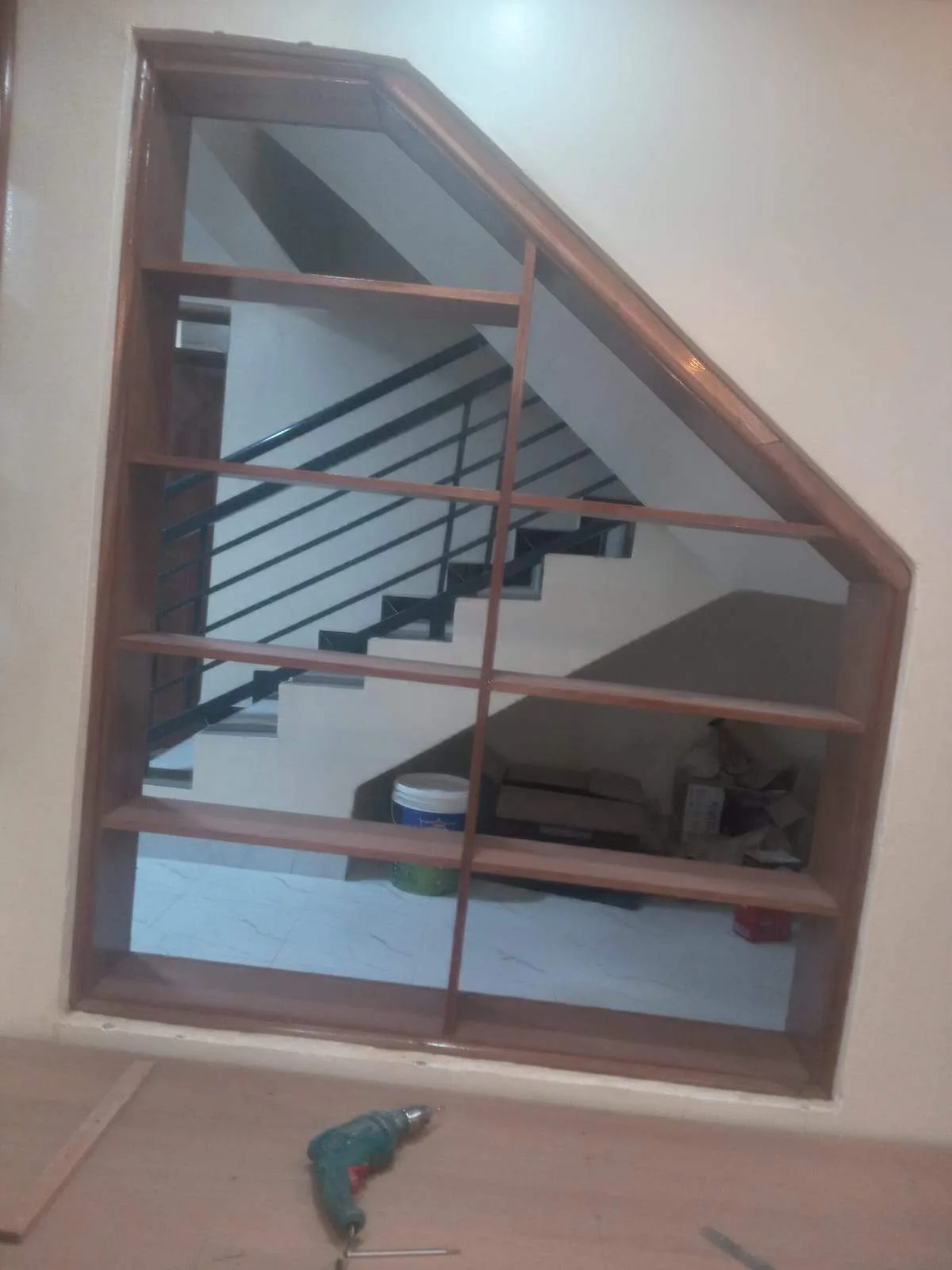 Wooden display shelf unit alongside a staircase