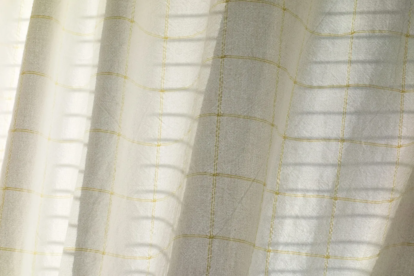 Sheer linen curtains diffusing daylight in a finished living room