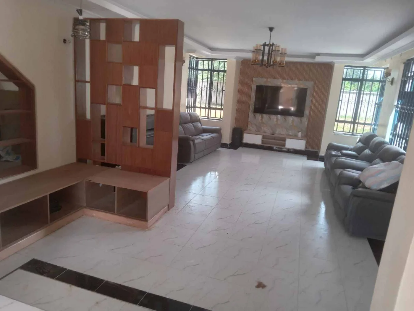 Glass-partitioned dressing area with dark framed panels in a Nairobi interior